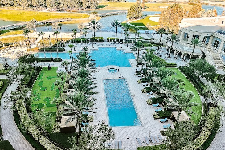 Pool area with its classic style and the golf course in the distance